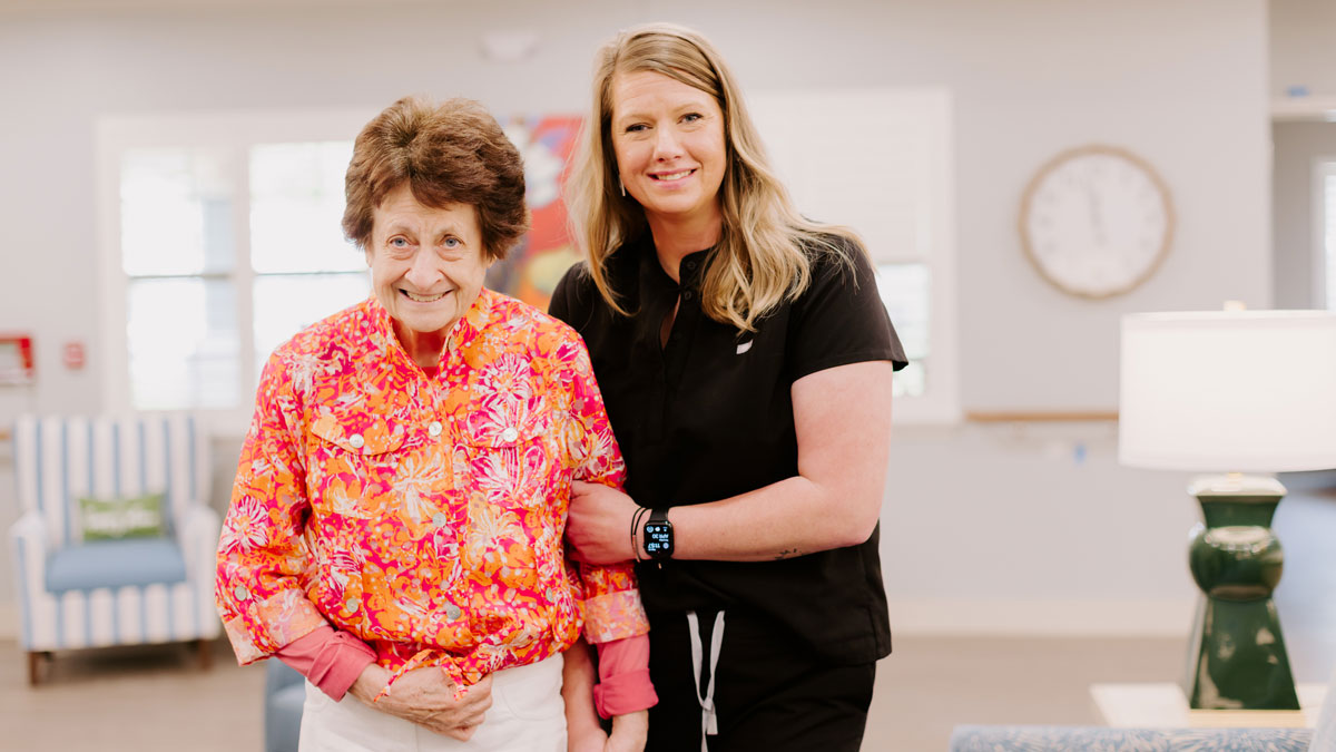 elder walking with assistance from nurse